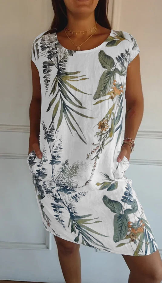 Women's relaxed shift dress featuring a vibrant botanical print, perfect for summer casual wear, designed with convenient side pockets for added functionality. 0