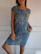 Women's relaxed shift dress featuring a vibrant botanical print, perfect for summer casual wear, designed with convenient side pockets for added functionality. 1