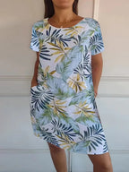 Women's relaxed shift dress featuring a vibrant botanical print, perfect for summer casual wear, designed with convenient side pockets for added functionality. 11