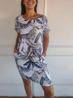 Women's relaxed shift dress featuring a vibrant botanical print, perfect for summer casual wear, designed with convenient side pockets for added functionality. 2