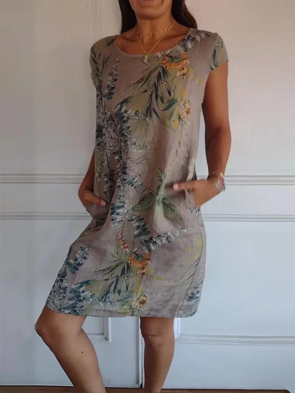 Women's relaxed shift dress featuring a vibrant botanical print, perfect for summer casual wear, designed with convenient side pockets for added functionality. 3