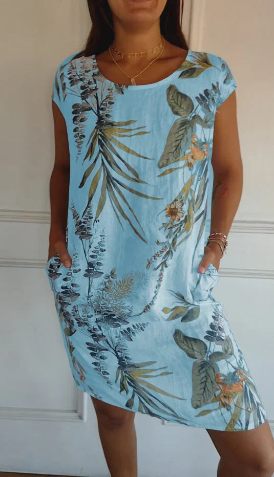 Women's relaxed shift dress featuring a vibrant botanical print, perfect for summer casual wear, designed with convenient side pockets for added functionality. 7