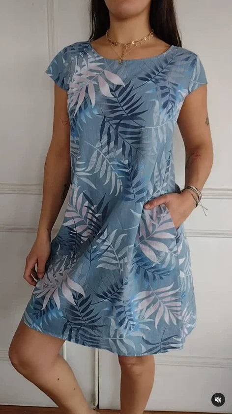 Women's relaxed shift dress featuring a vibrant botanical print, perfect for summer casual wear, designed with convenient side pockets for added functionality. 9